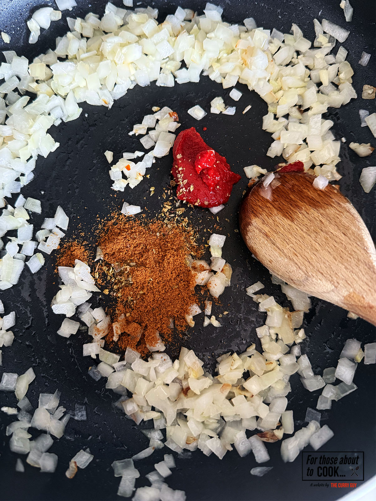 Spices and tomato puree added to the pan