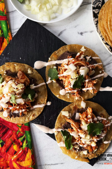 Tostadas de tinga drizzled with chipotle mayo and sprinkled with coriander