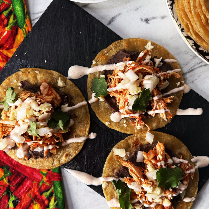 Tostadas de tinga drizzled with chipotle mayo and sprinkled with coriander