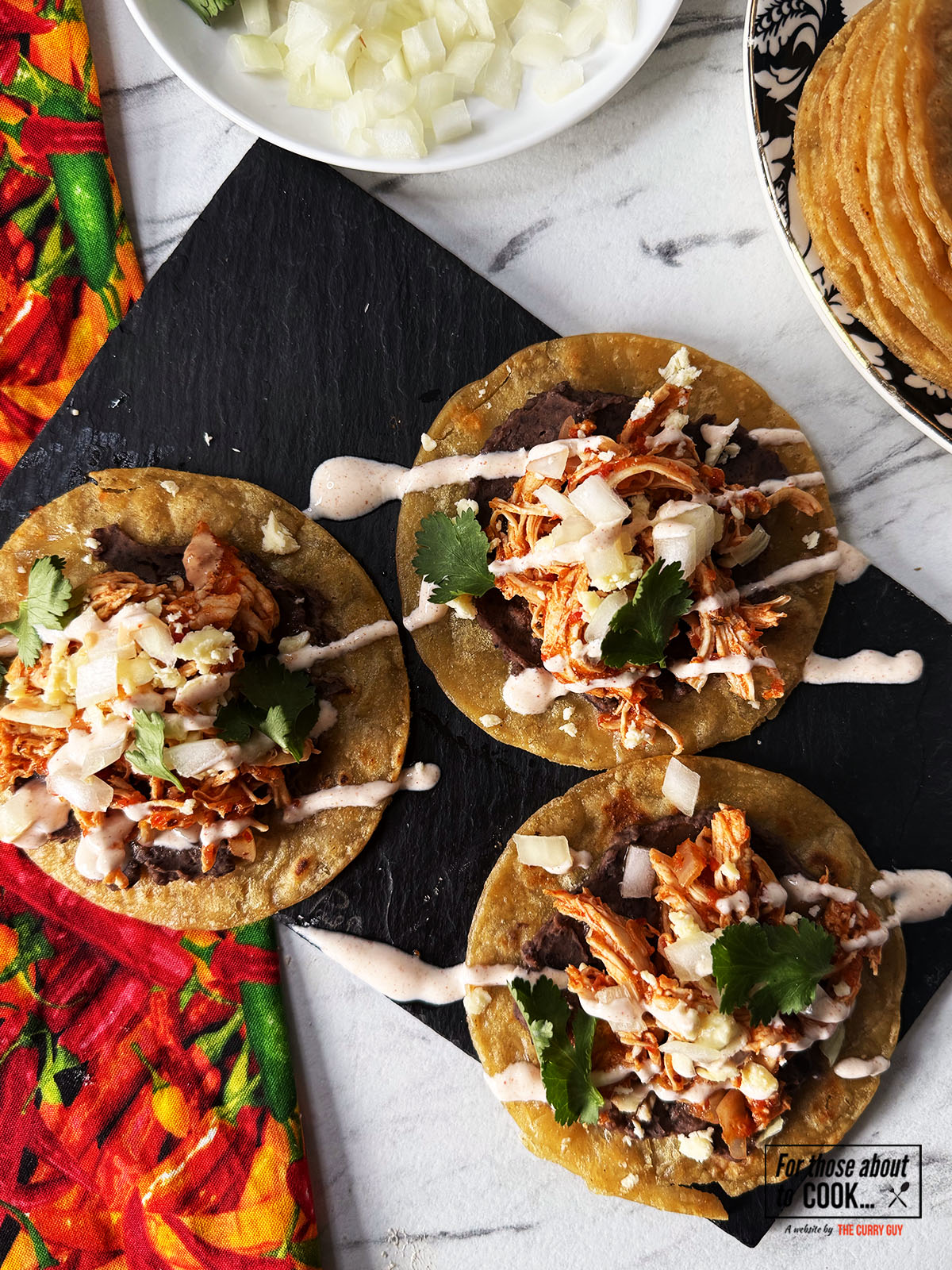 Tostadas de tinga drizzled with chipotle mayo and sprinkled with coriander 