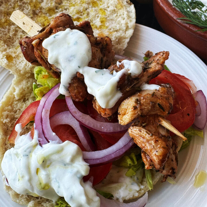 Chicken souvlaki served on a pita with crispy salad vegetables and tzatziki.