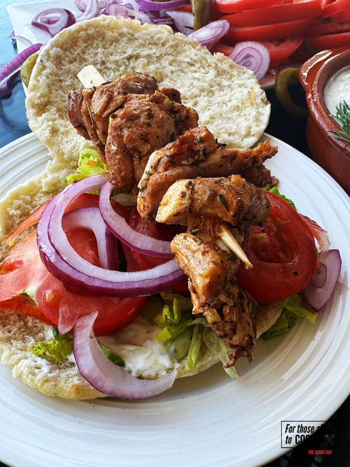 Chicken souvlaki on a pita with salad vegetables.