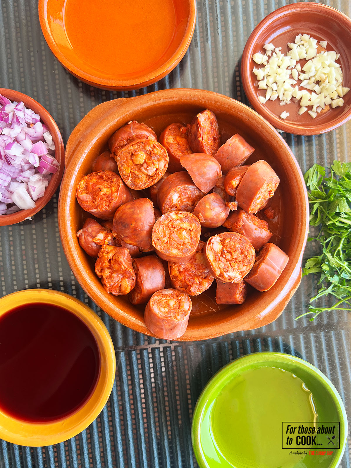 Ingredients for chorizo Al vino separated into bowls