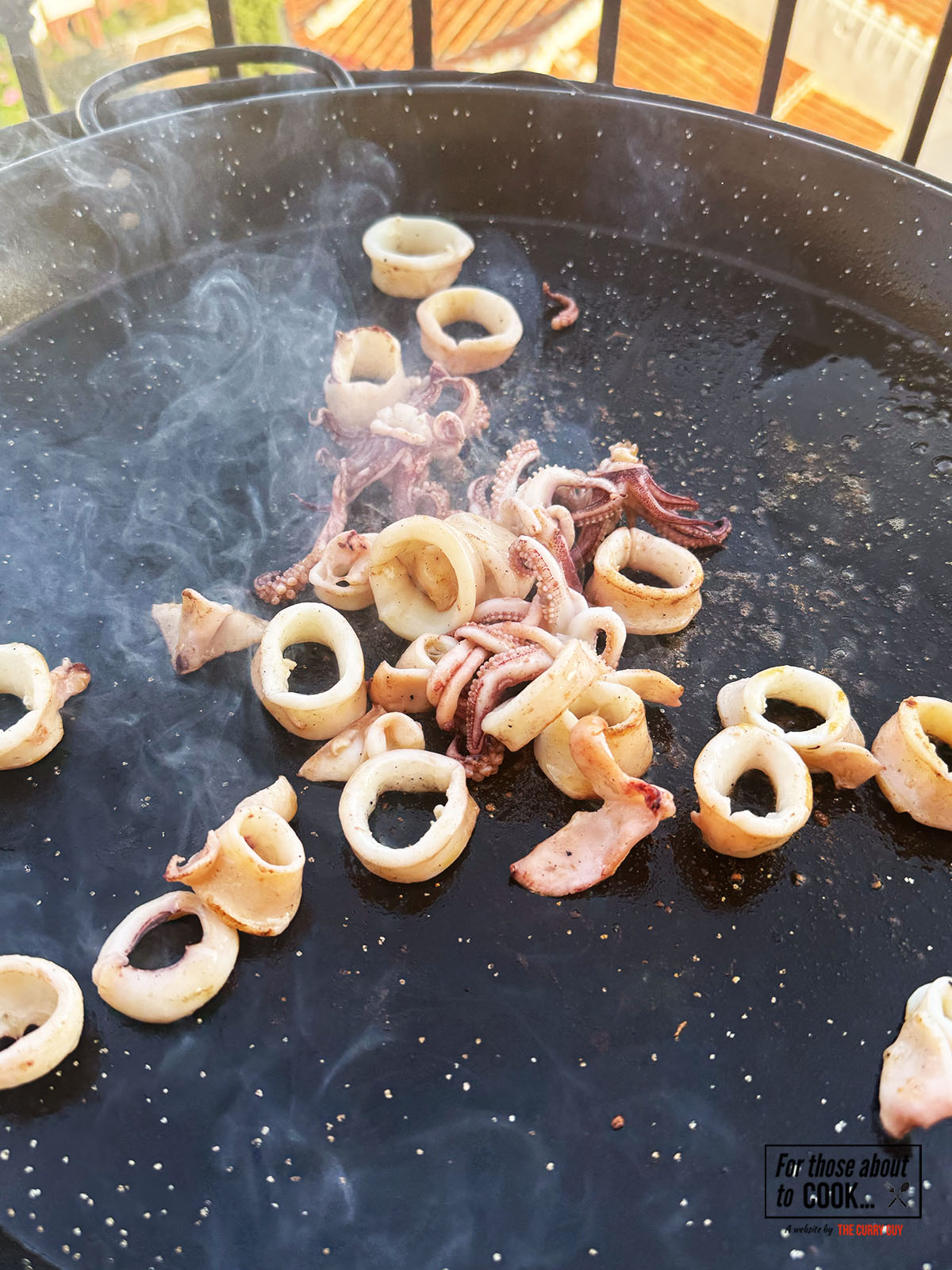 Squid added to the paella pan and fried until charred