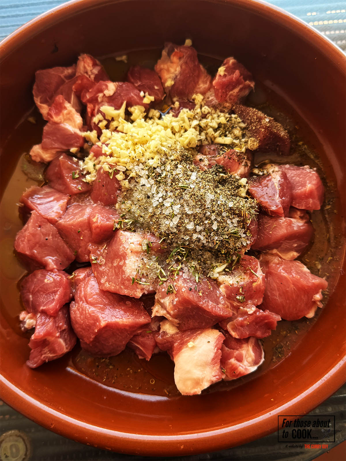Adding the marinade ingredients to the pork in a bowl.