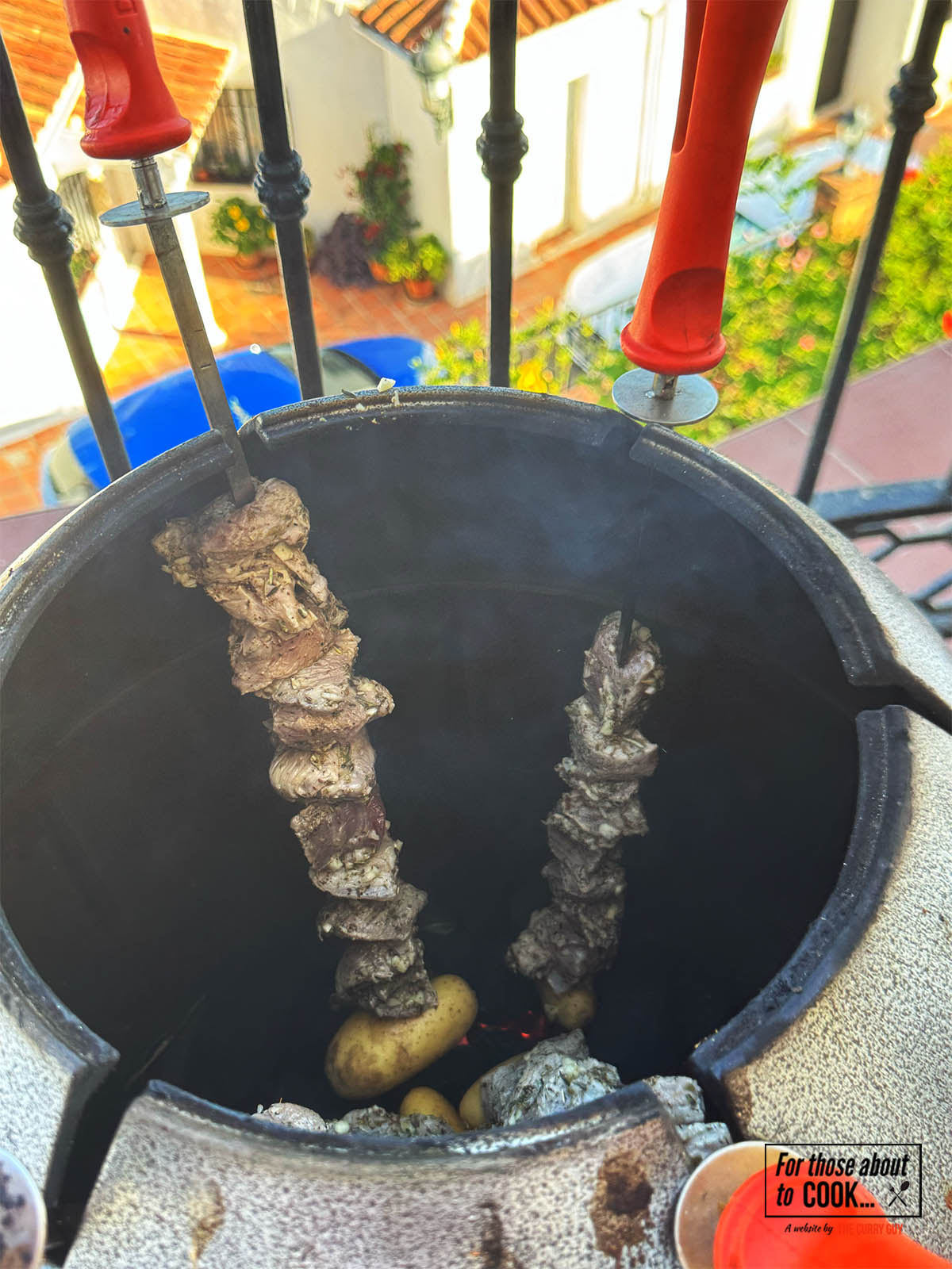 Cooking the pork souvlaki in a tandoor oven.
