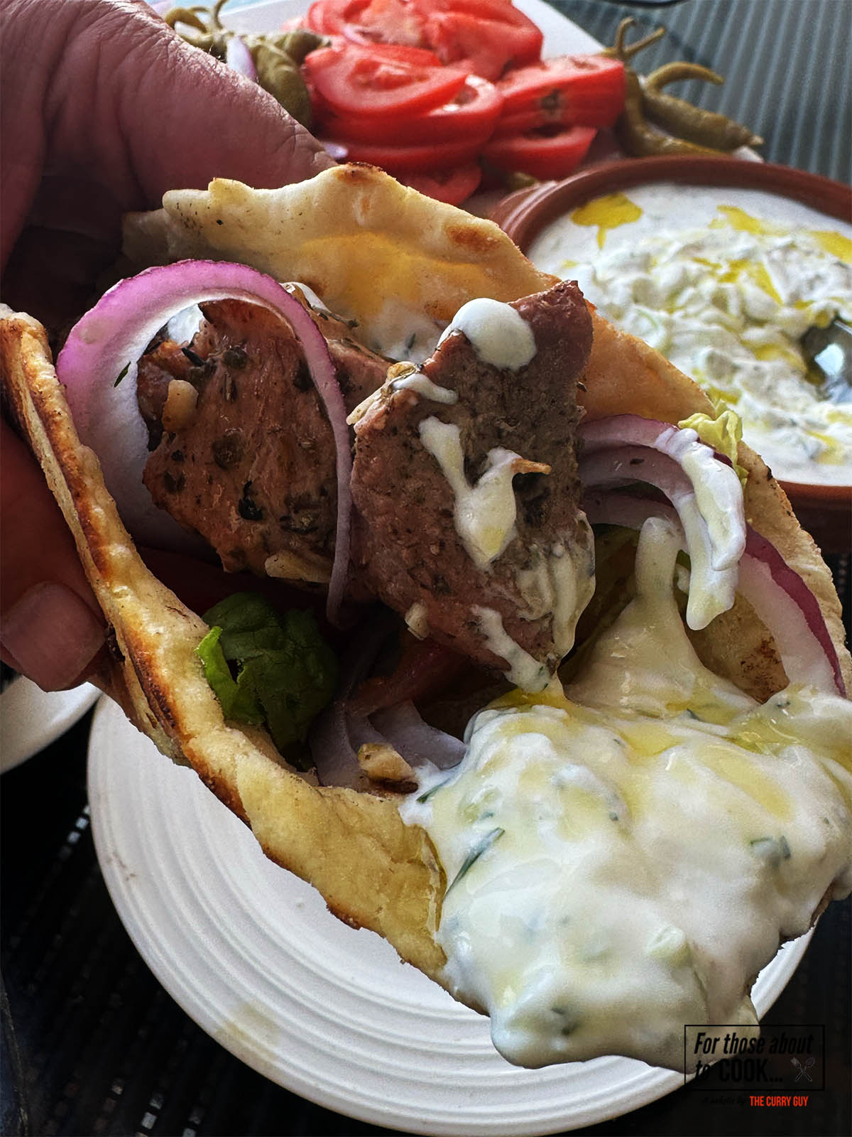 Pork souvlaki rolled up in a pita with tzatziki and crisp salad veggies.