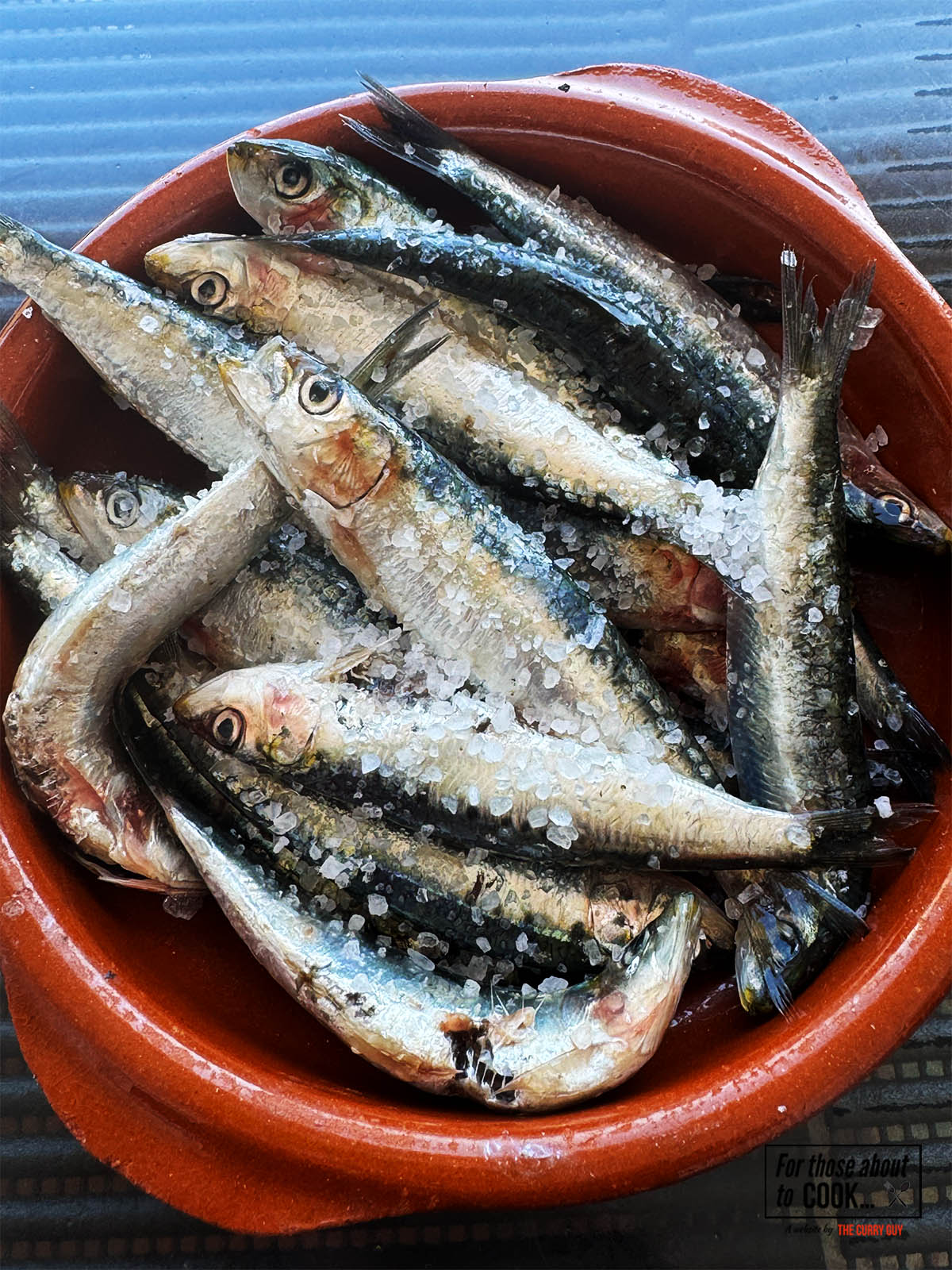 Mixing the sardines with sea salt in a bowl.