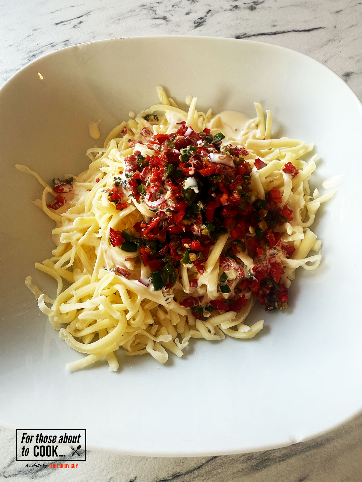 Cheese, cream and chopped chillies mixed in a bowl