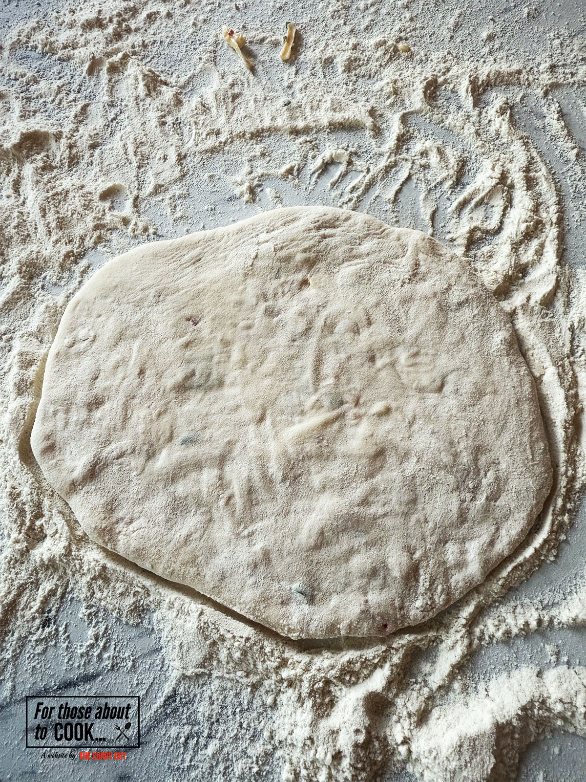 Pressing the chili cheese naan down and flattening it