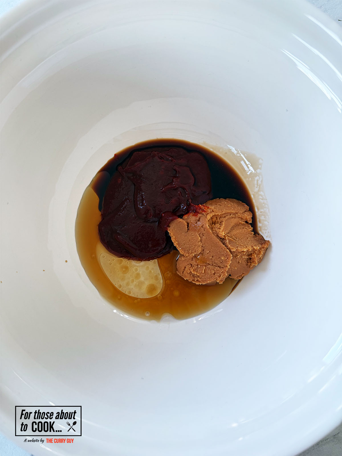 Miso and gochujang in a bowl with sesame oil and rice vinegar