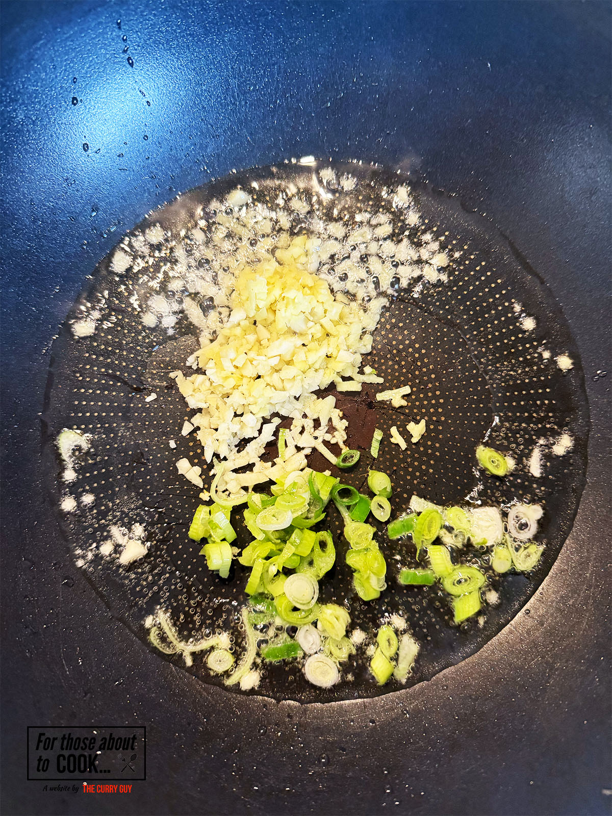 garlic and spring onion frying in a pan
