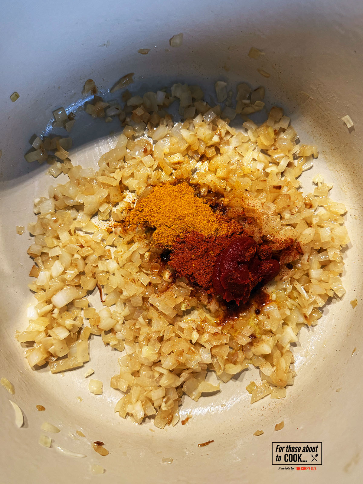Tomato paste and spices added to the pan