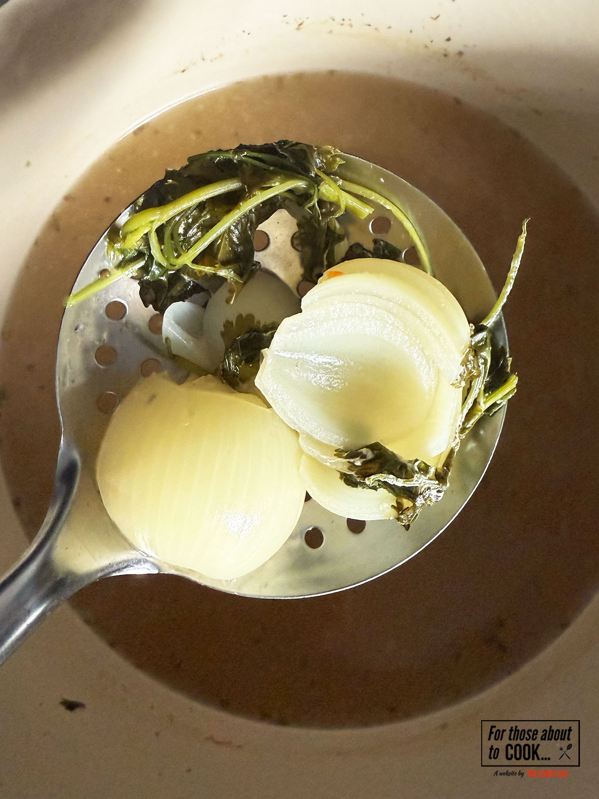 removing the onions from the stock for pozole verde