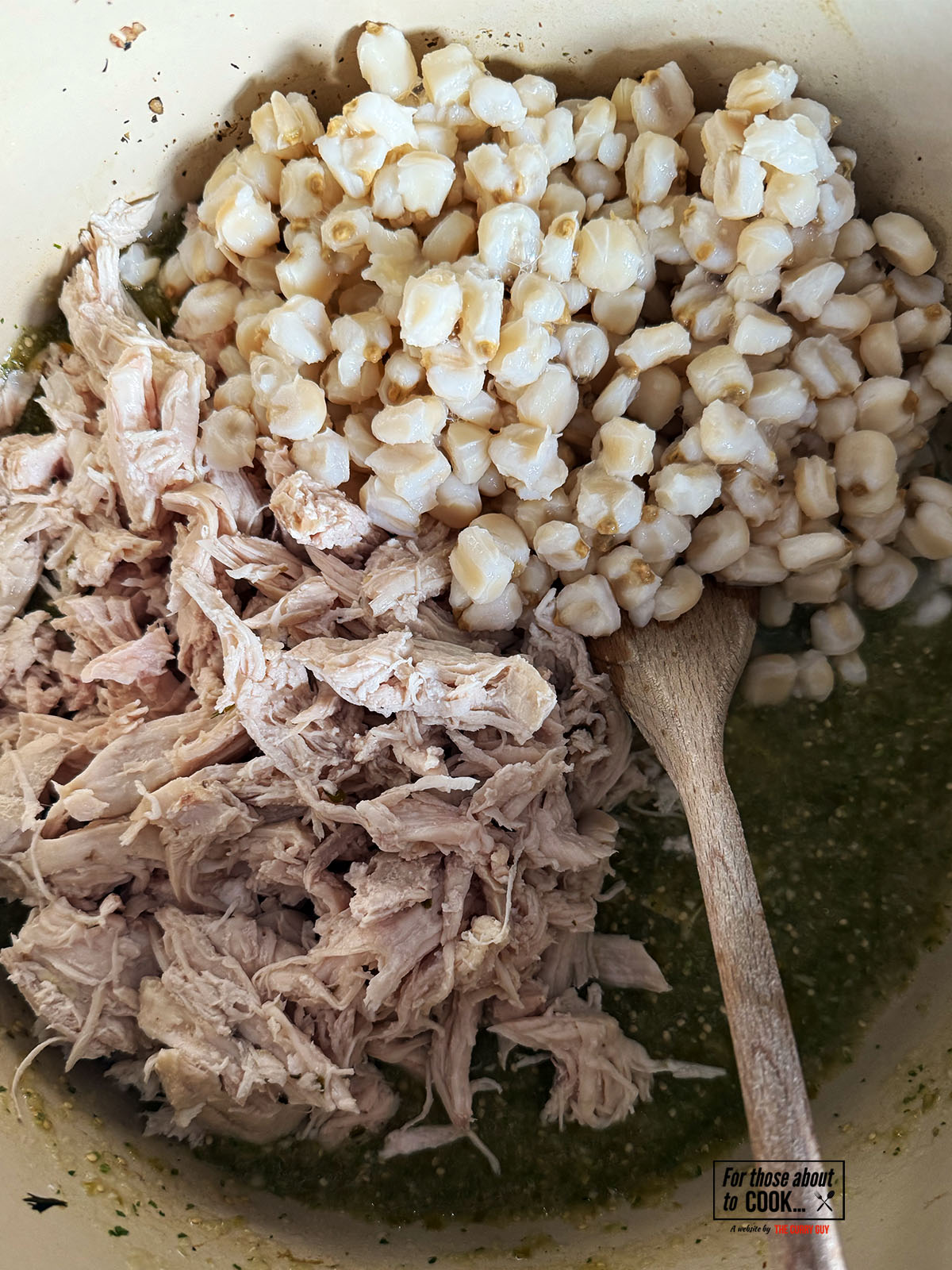 Adding the hominy and shredded chicken to the salsa verde