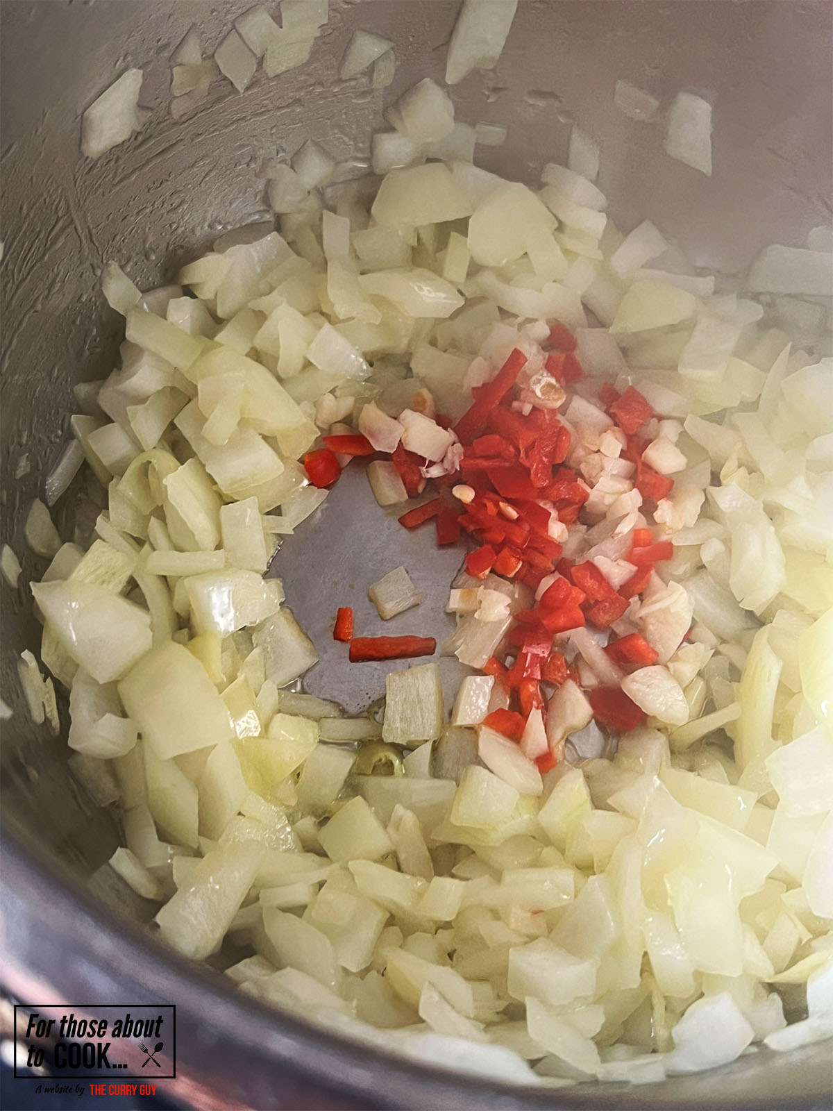 adding chopped garlic and chilies to the onions