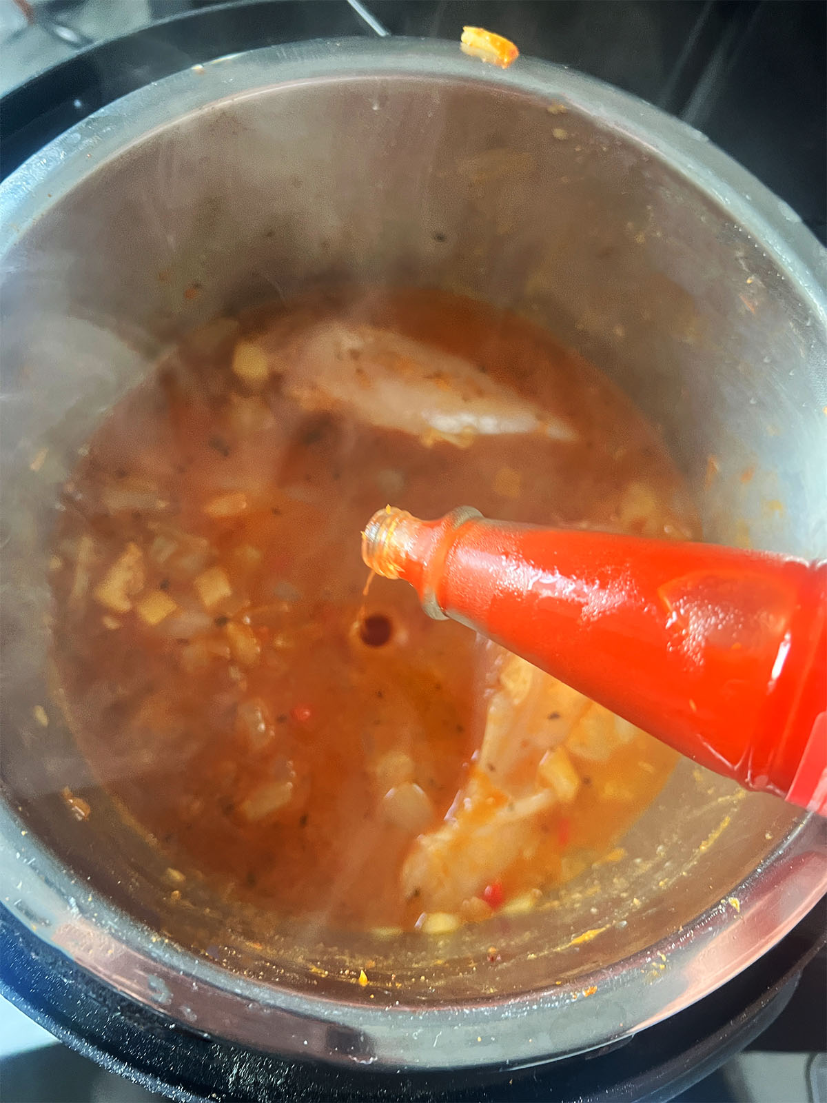 adding hot sauce to the recipe