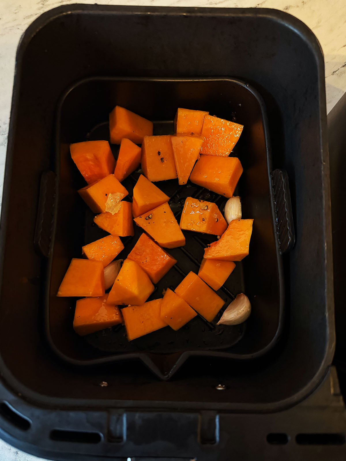 Butternut squash and garlic in the air fryer ready to roast