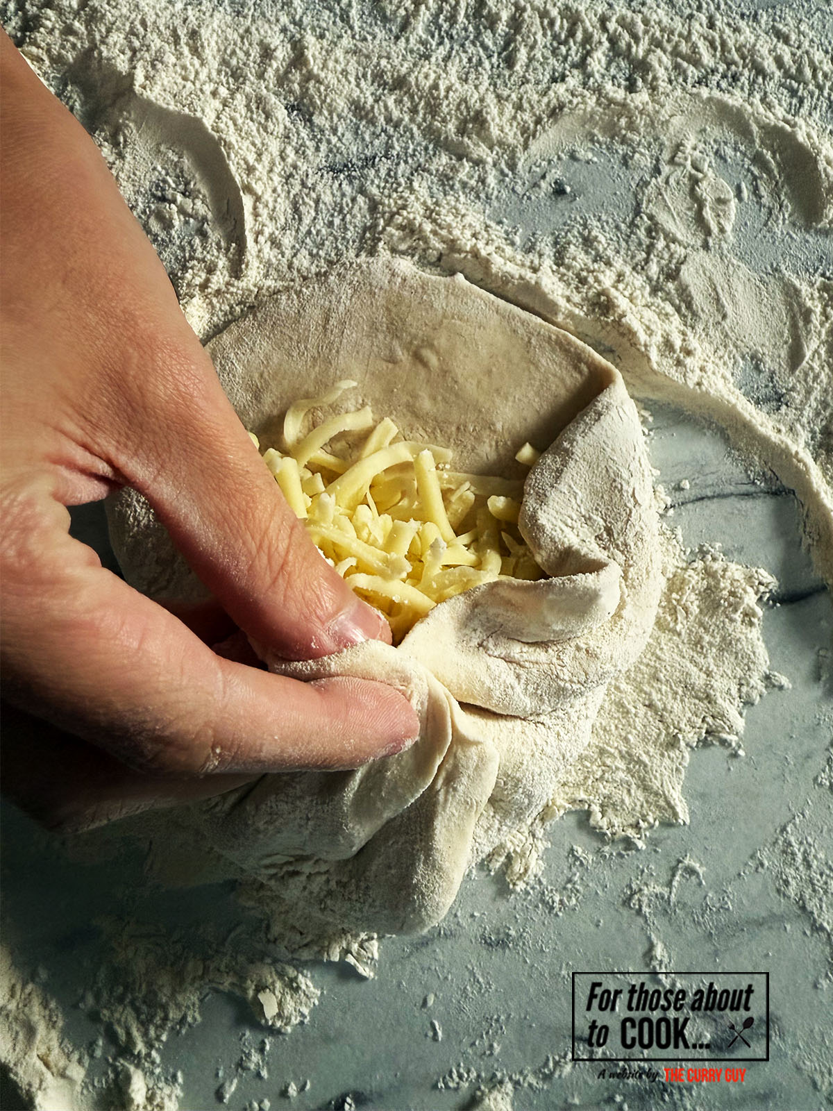 pinching and folding the sides of the dough for cheese naan