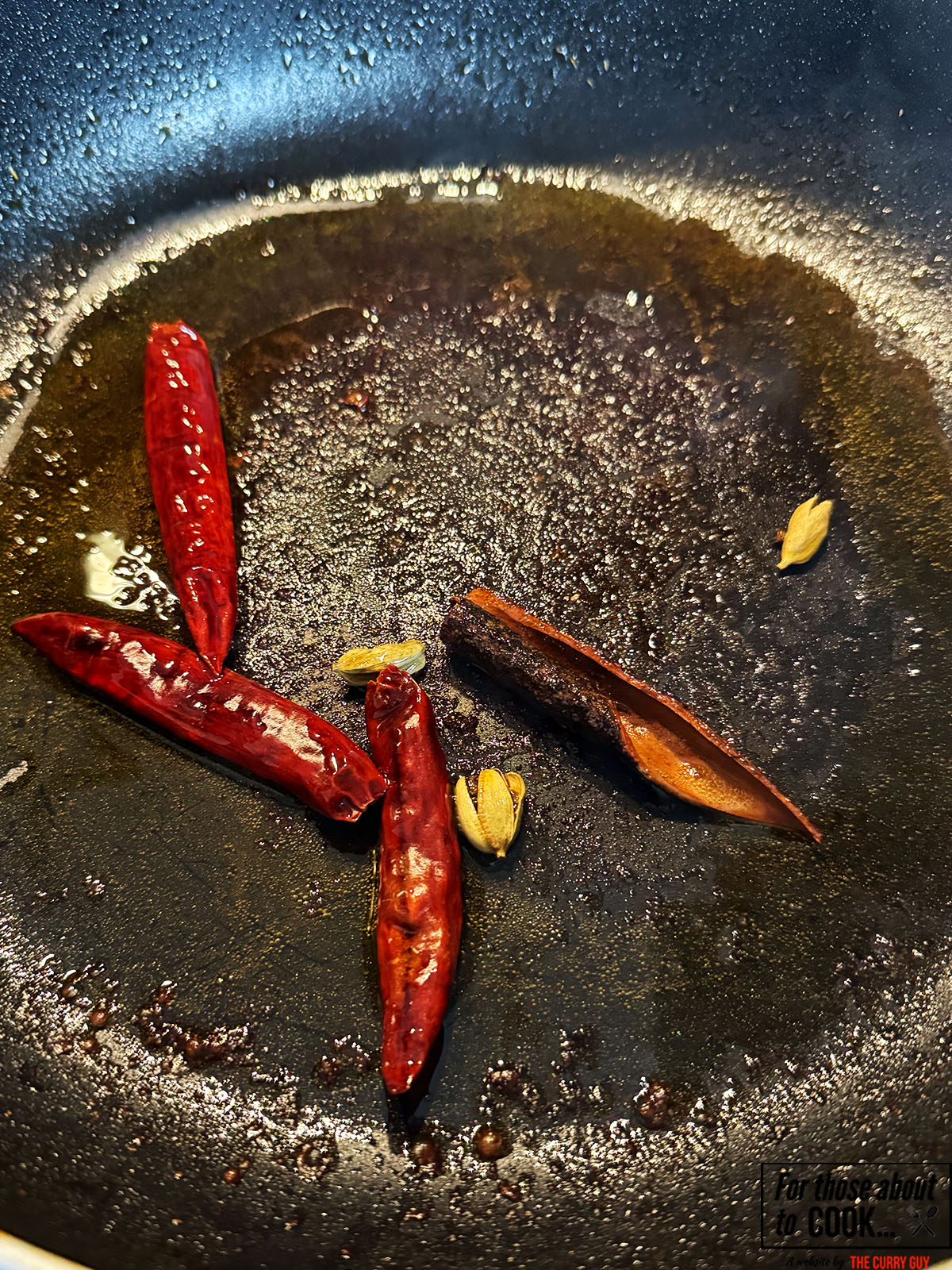 Whole spices and chillies frying in a pan