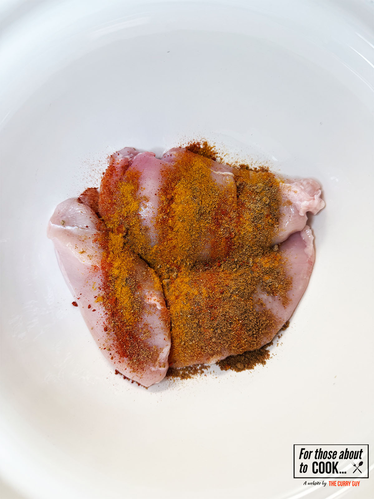 coating the chicken in the spices for coconut chicken