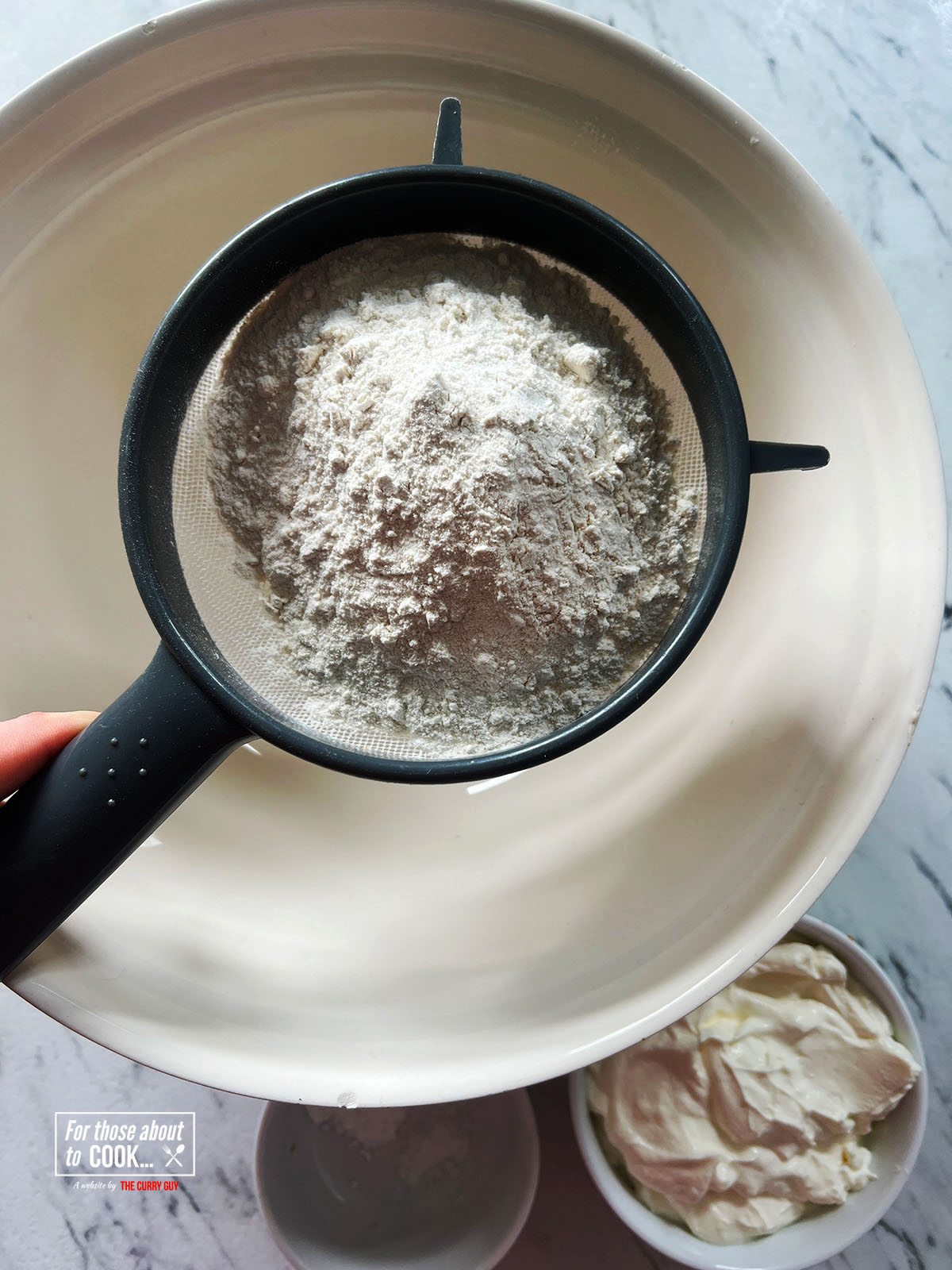 Sifting flour into a bowl