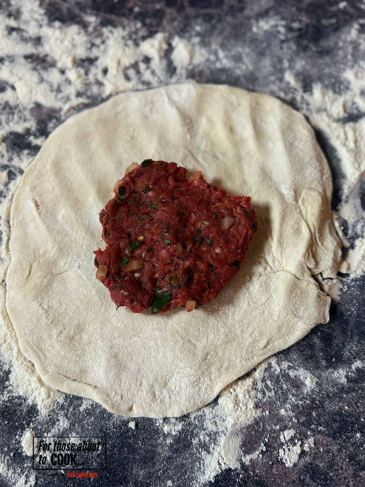 Naan dough rolled out and filled with Keema