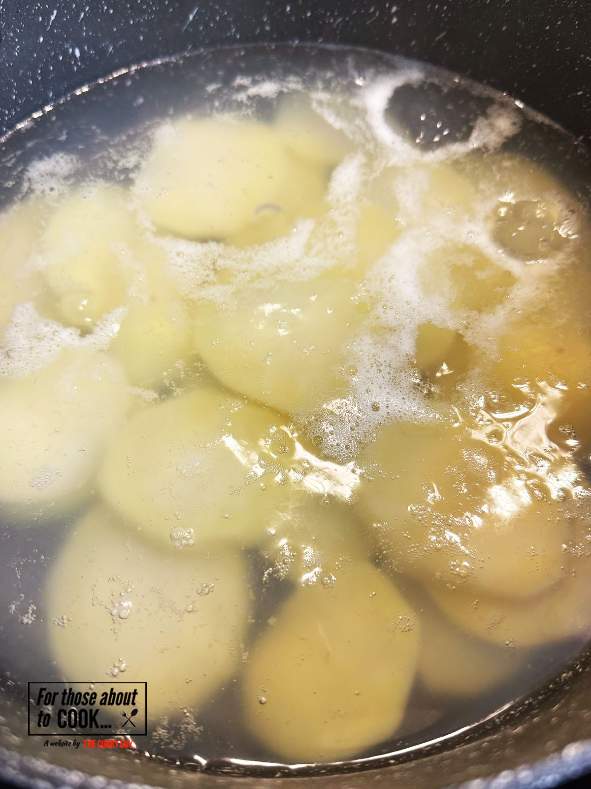 Sliced potatoes boiling in a pan of water 