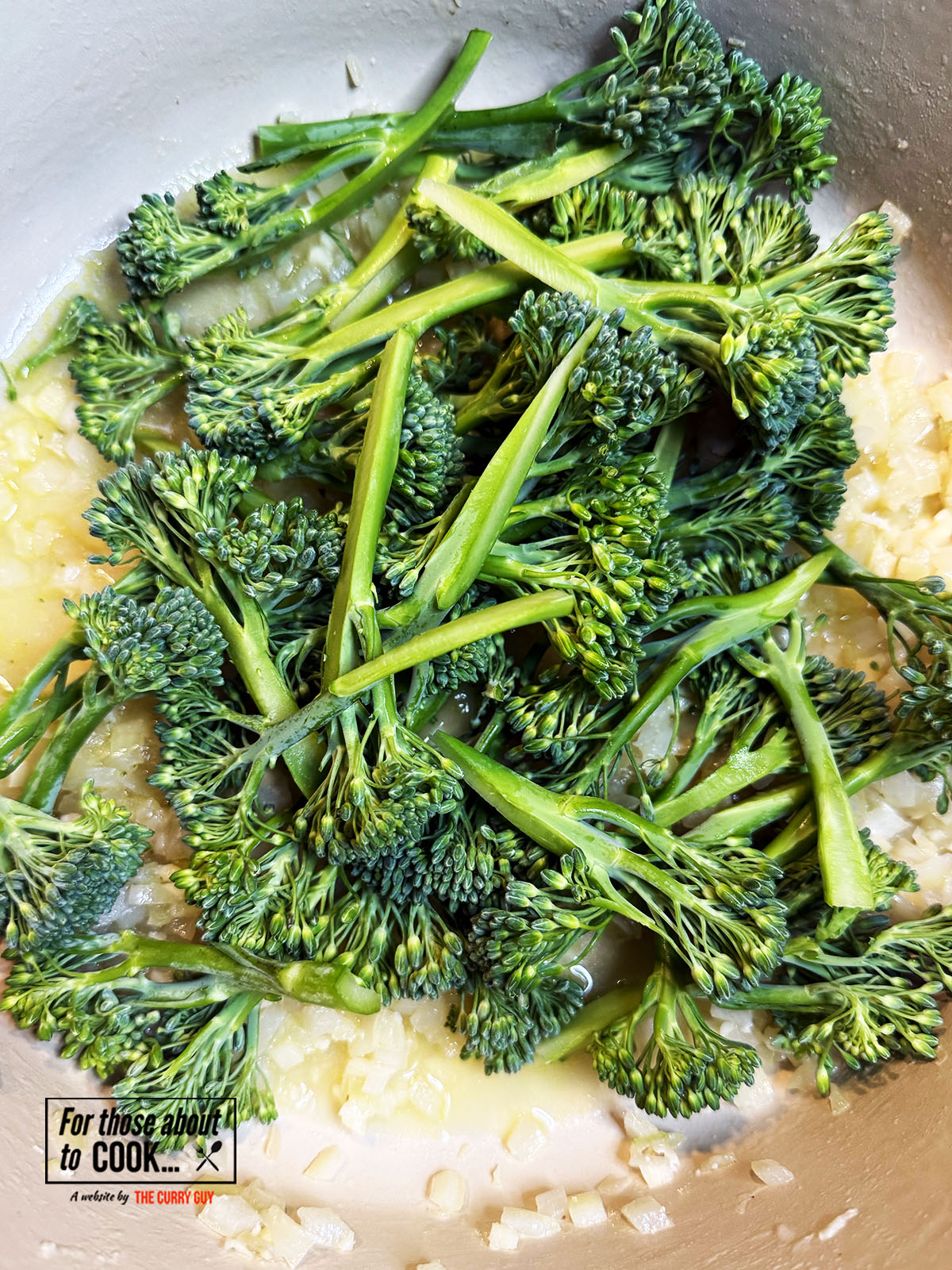 Chicken stock and broccoli added to the pan