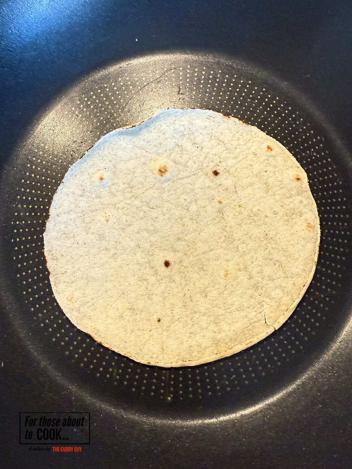 Heating tortillas on a pan until pliable