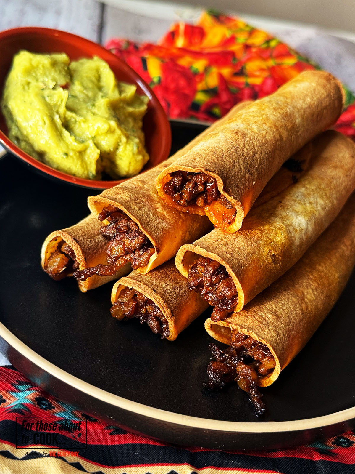 Spicy beef taquitos served with guacamole