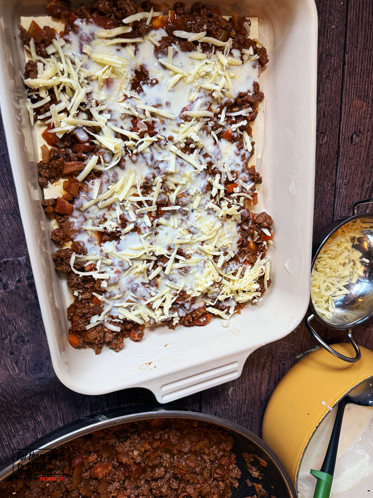 First layer of lasagne, meat, bechamel and cheese added to the baking dish