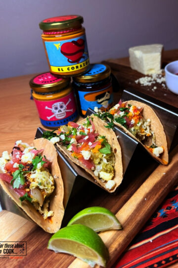 Salsa verde tacos topped with salsa and cheese