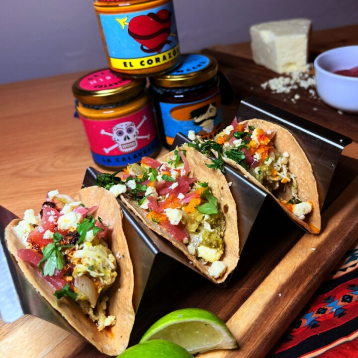 Salsa verde tacos topped with salsa and cheese