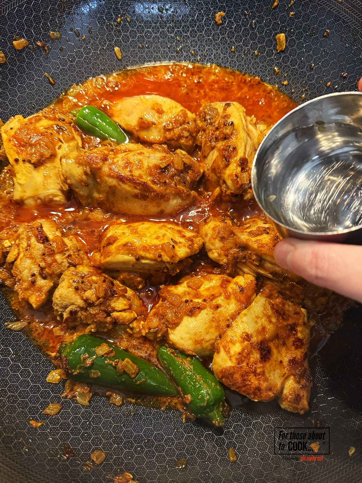 Chicken cooking in the pan with a splash of water