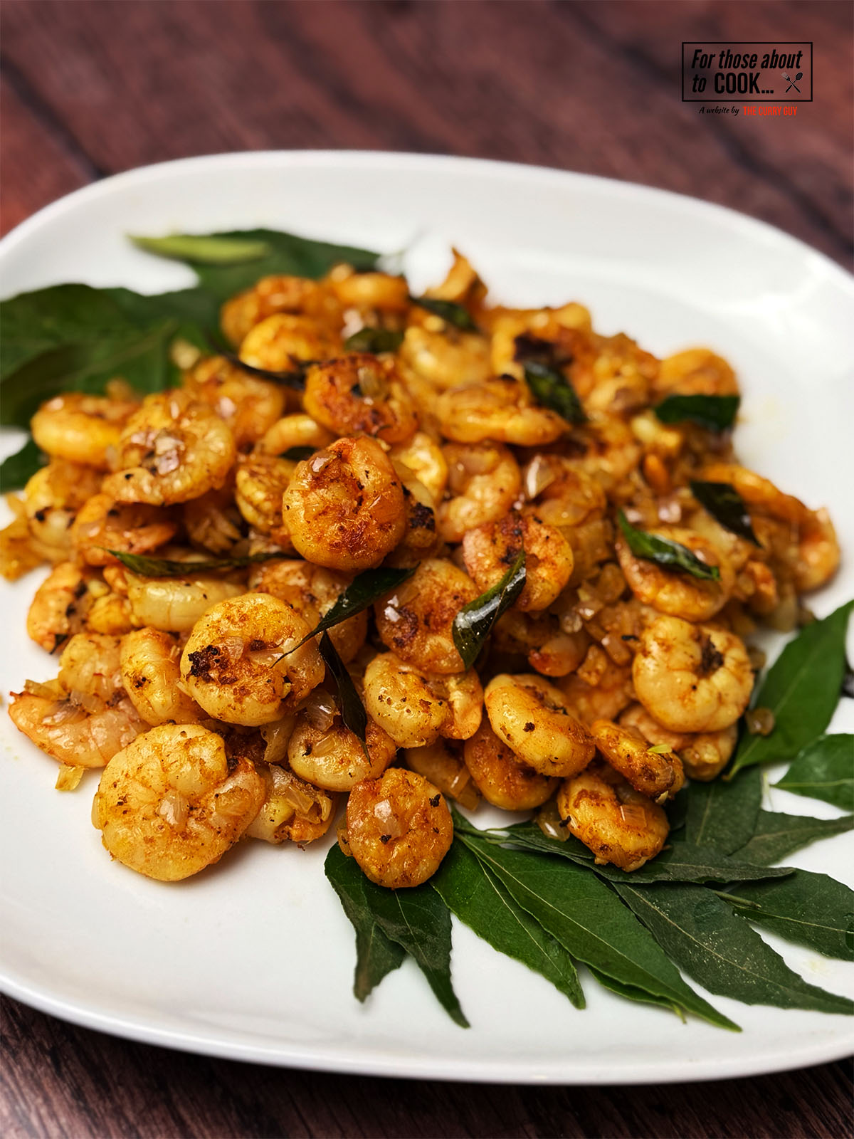 Kerala style prawn fry served on a bed on curry leaves and topped with crispy curry leaves