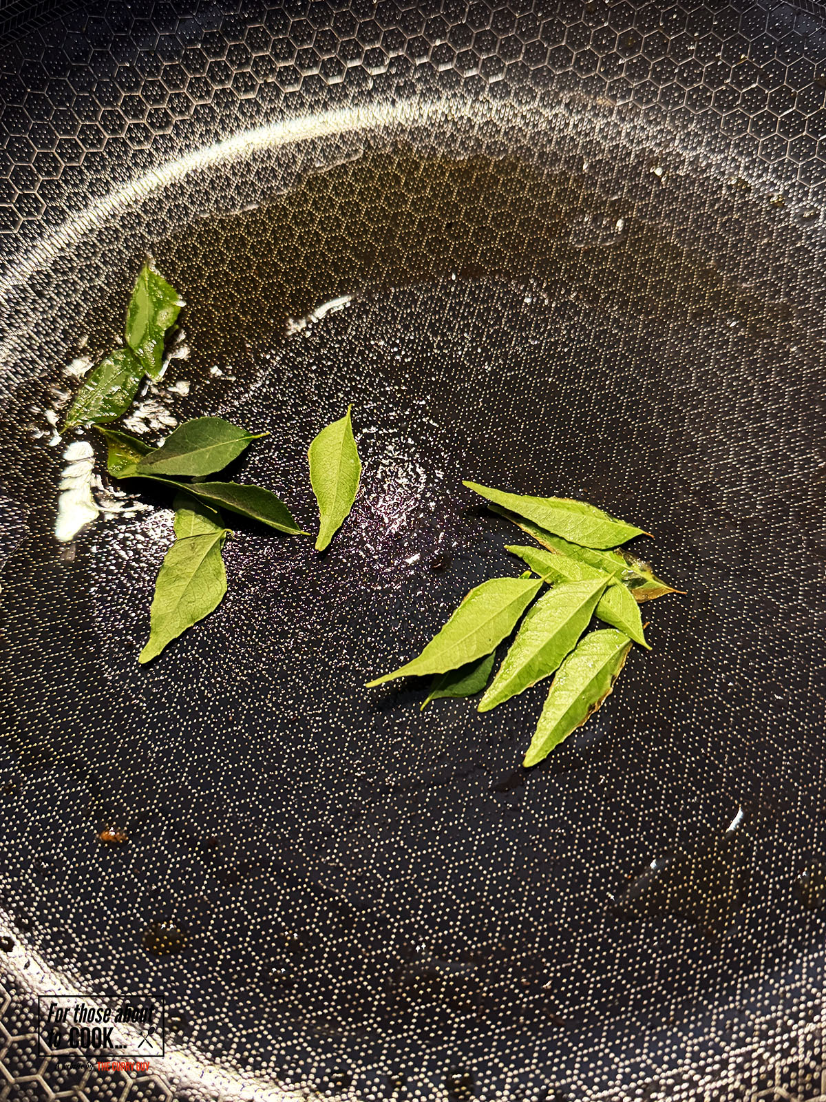 Curry leaves frying in coconut oil