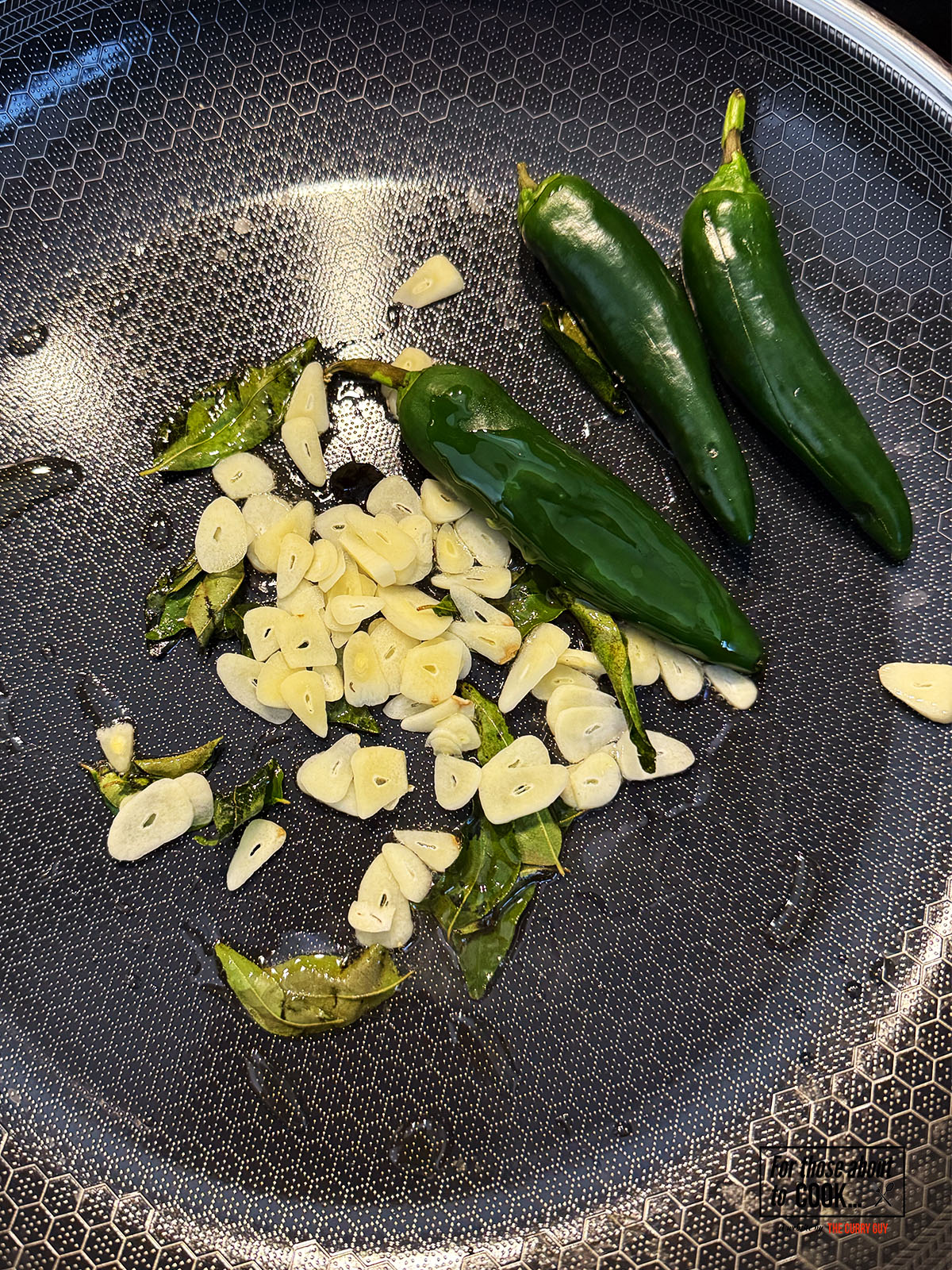 curry leaves and garlic frying in a pan 
