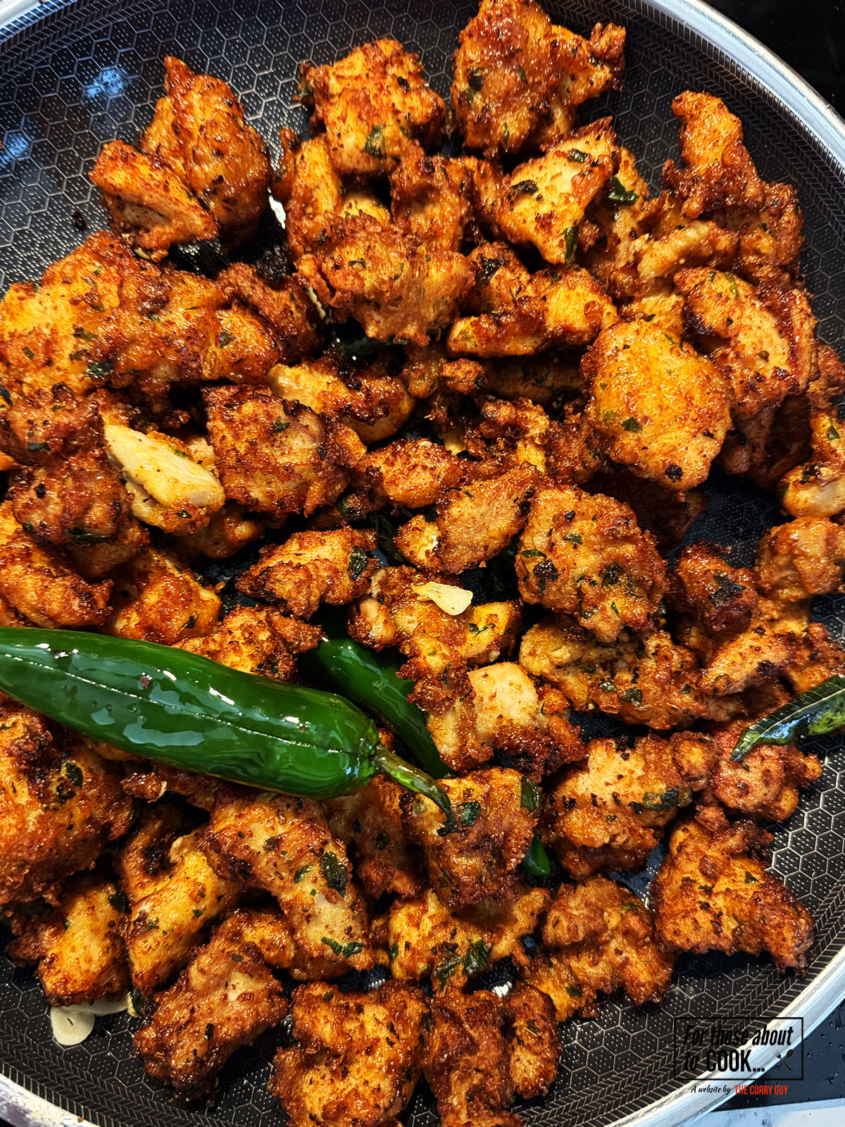 Chicken returned to the pan and tossed with the garlic and chillies