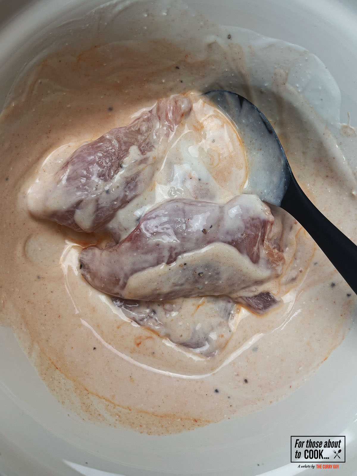 Chicken breast marinating in buttermilk and spices