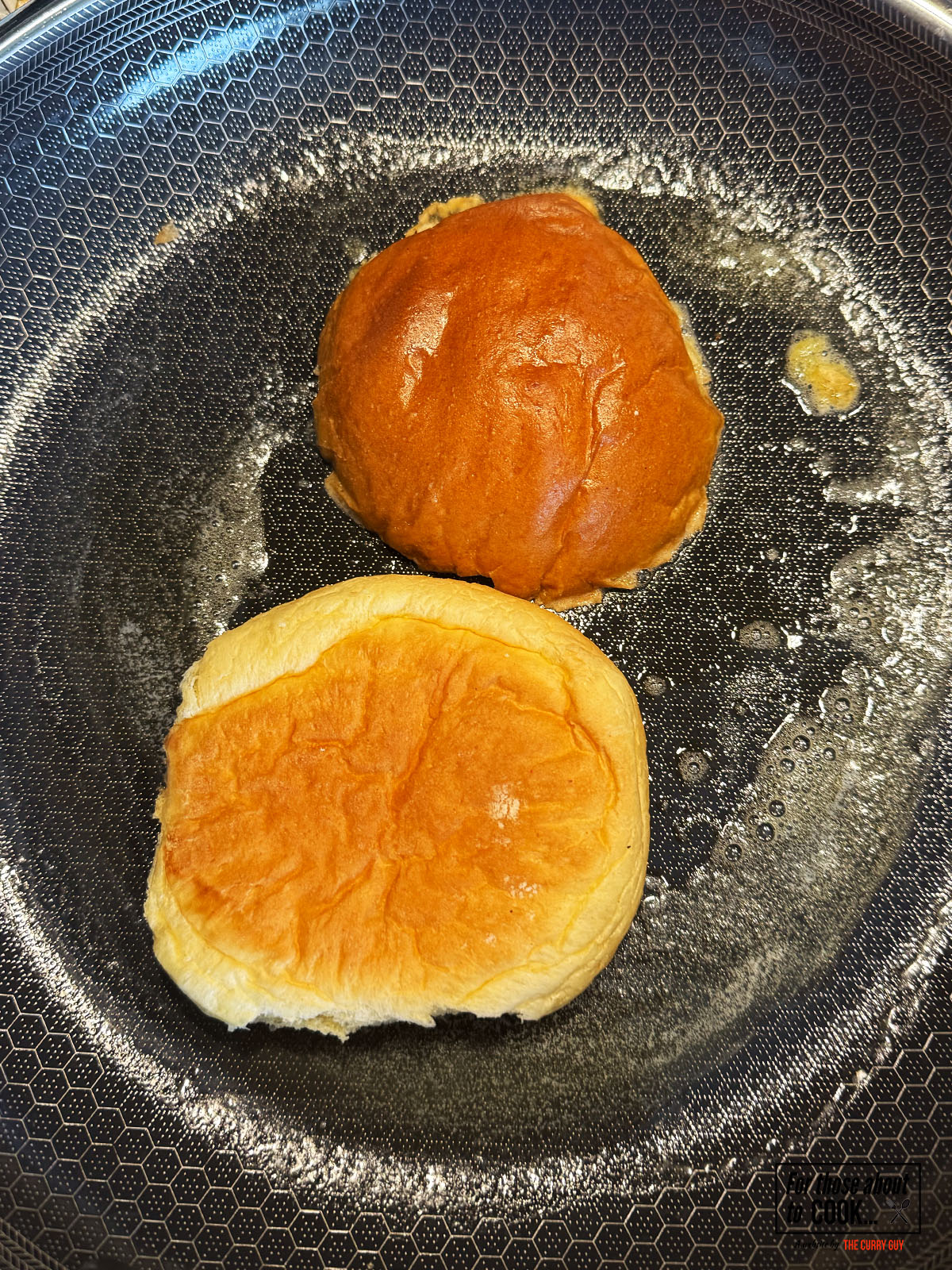 Brioche buns toasting in butter in a pan