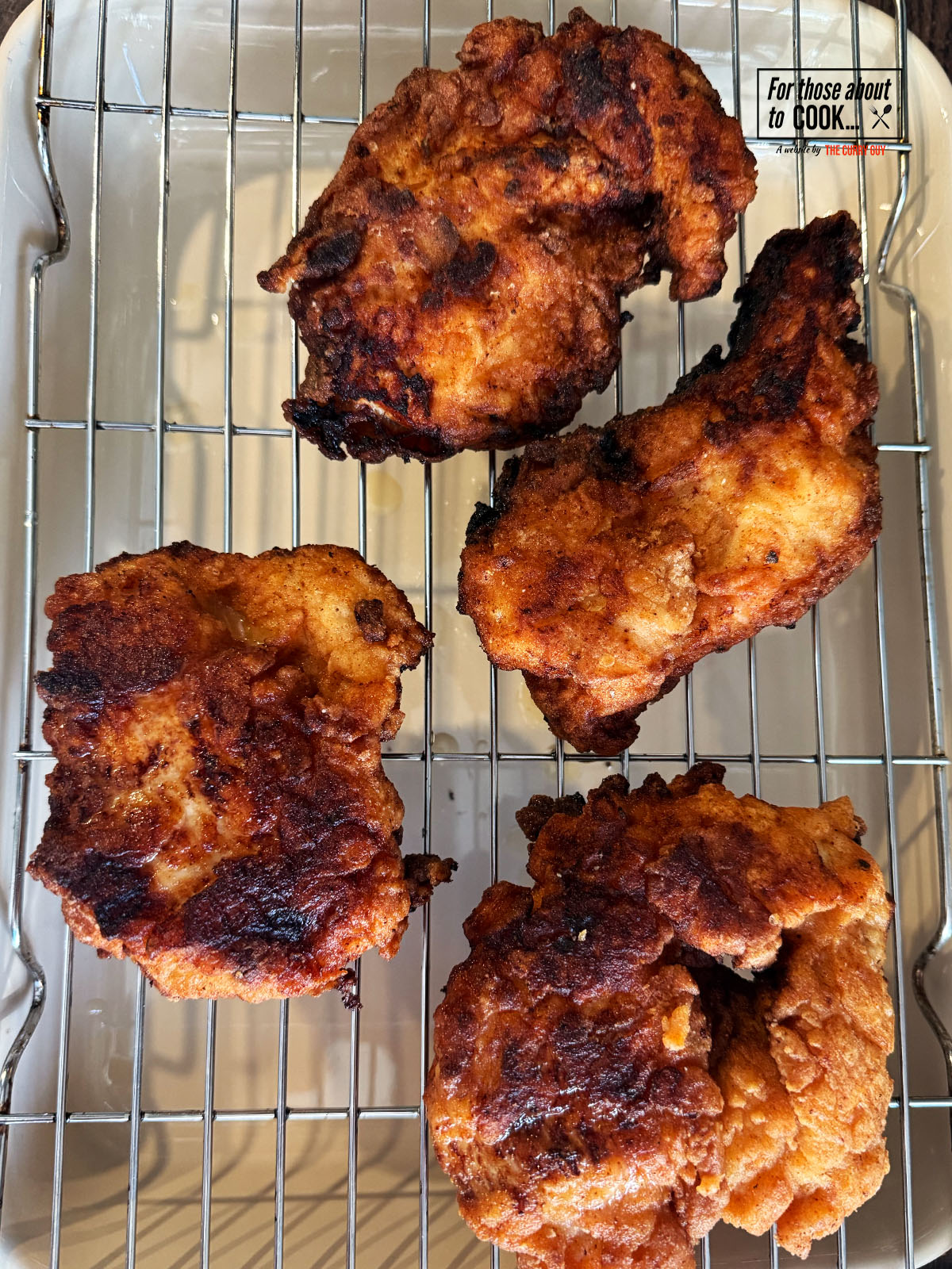 Fried chicken draining of oil on a rack 