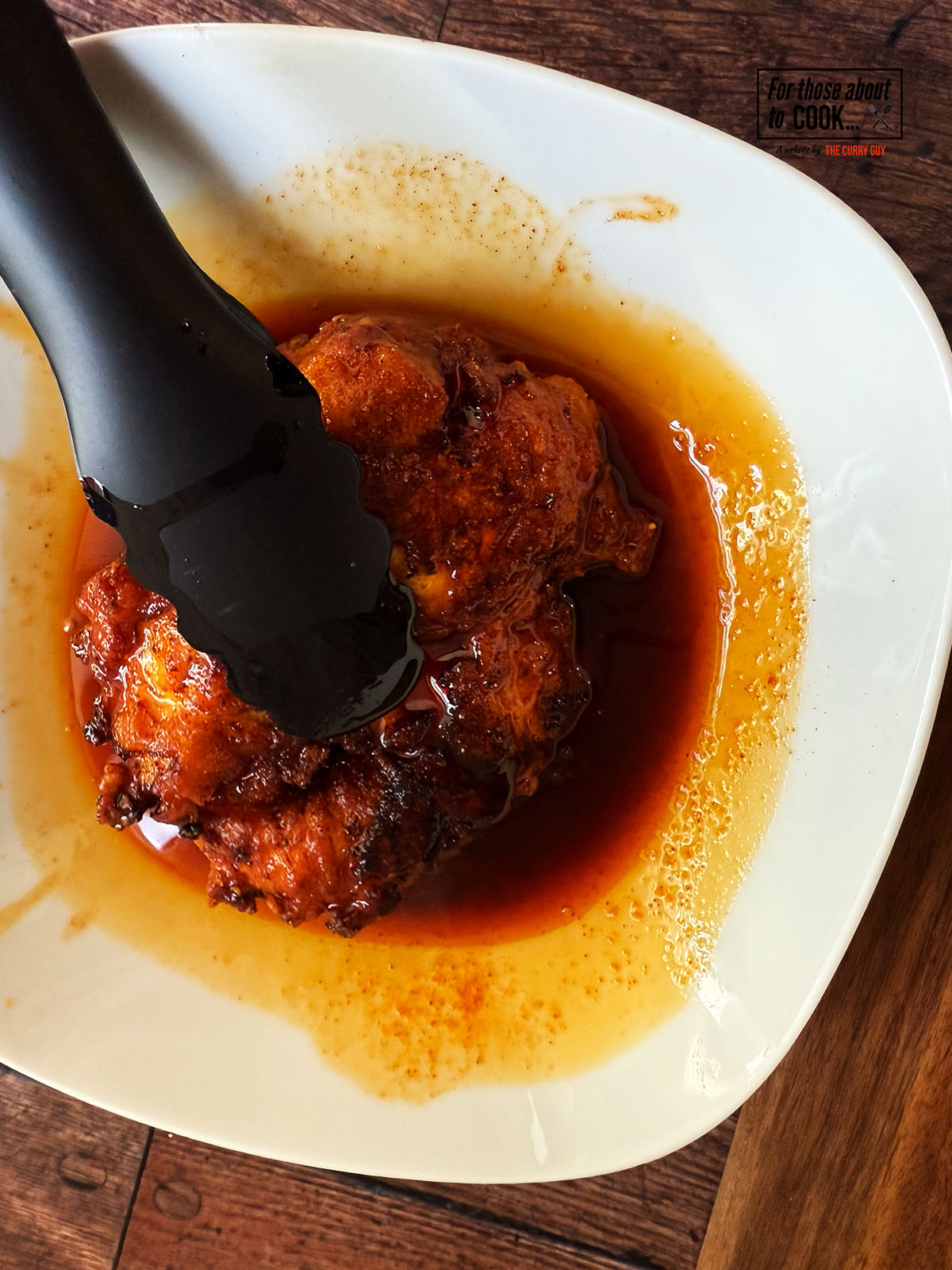 Fried chicken pieces dipped in the spiced oil
