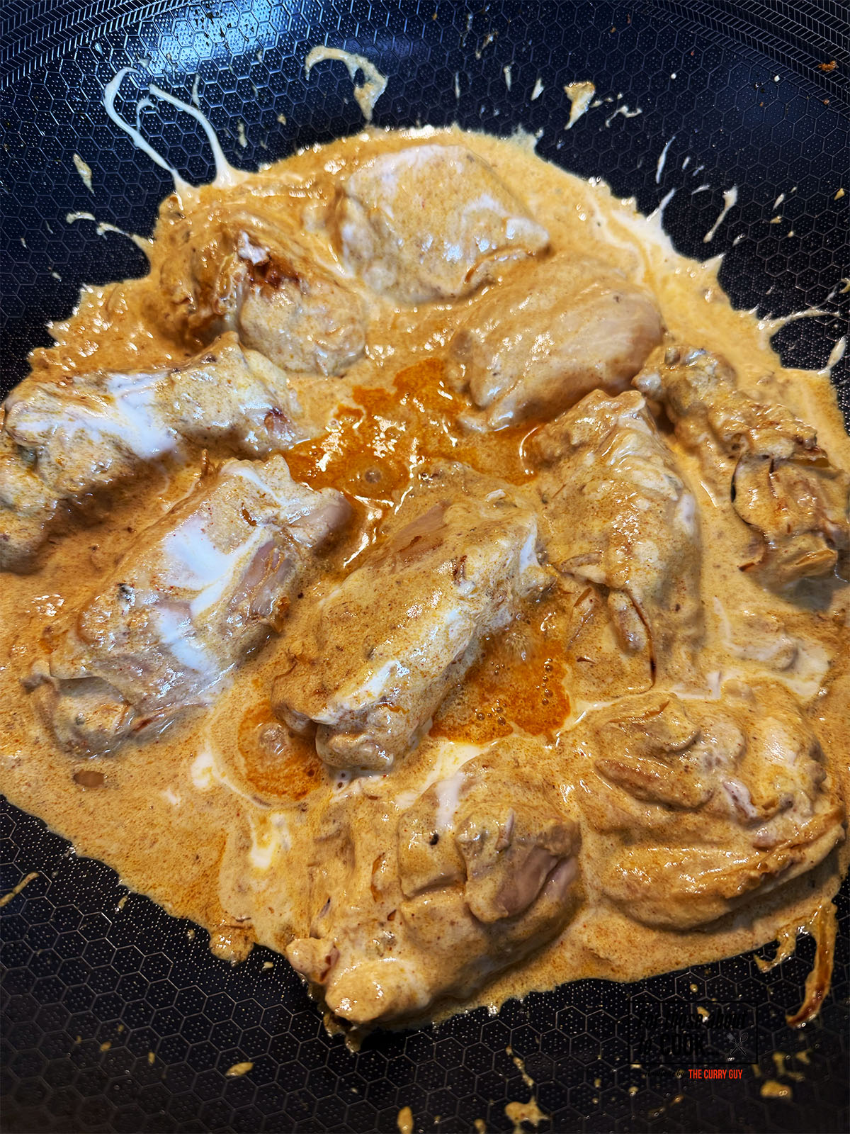 Chicken cooking in the yoghurt until cooked through