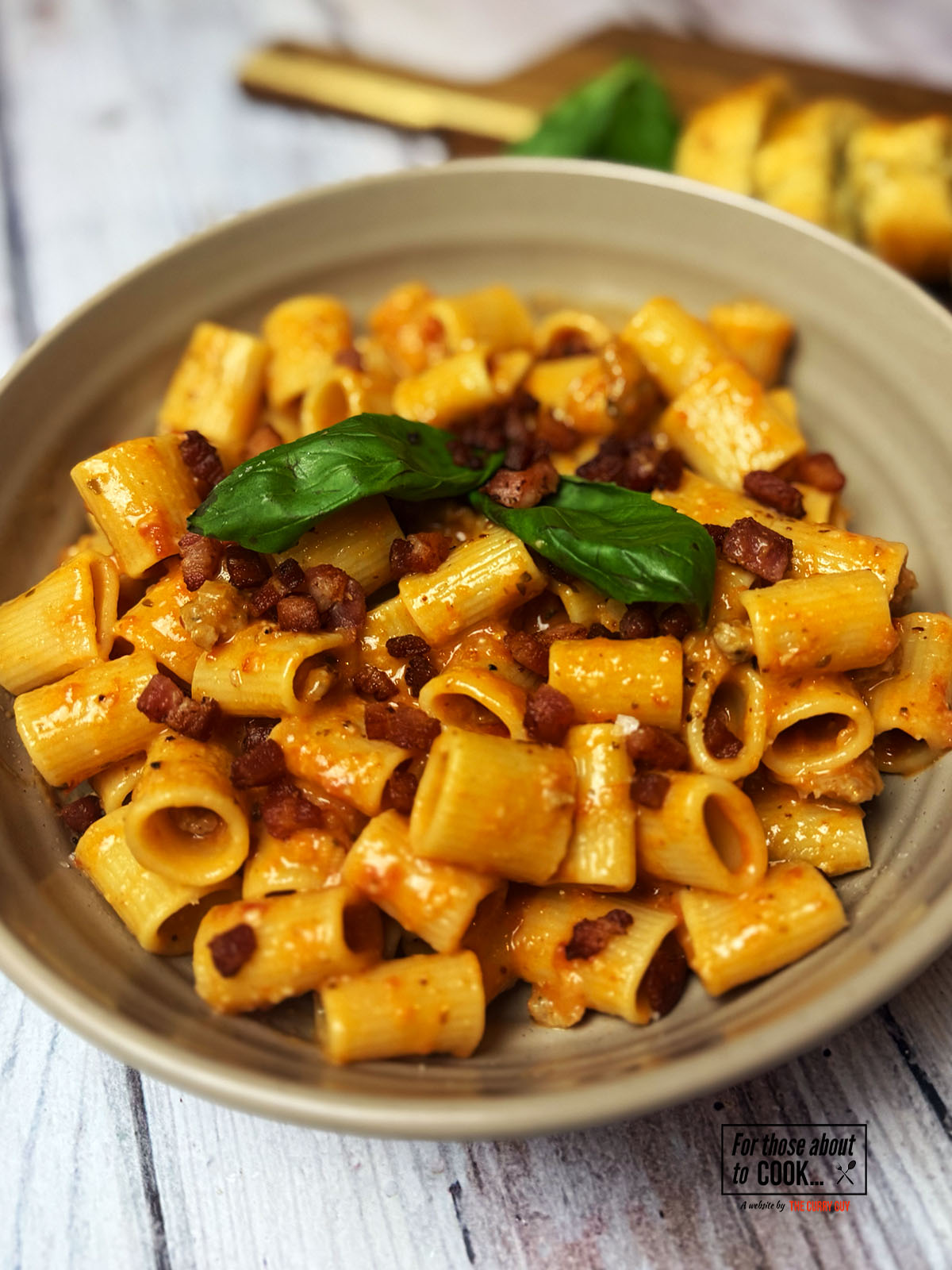 Pasta alla zozzona served in a bowl topped with pancetta and basil