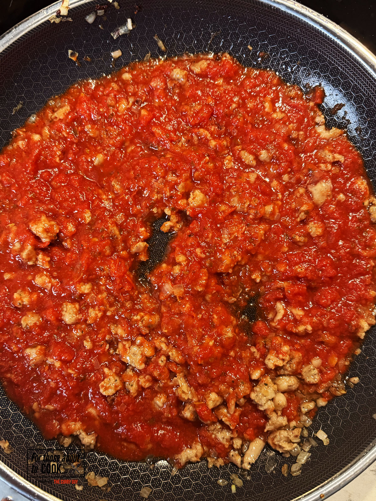 Passata added to the pan with the sausage and shallots