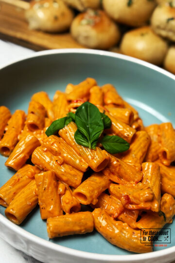 Spicy vodka pasta served in a bowl and topped with basil