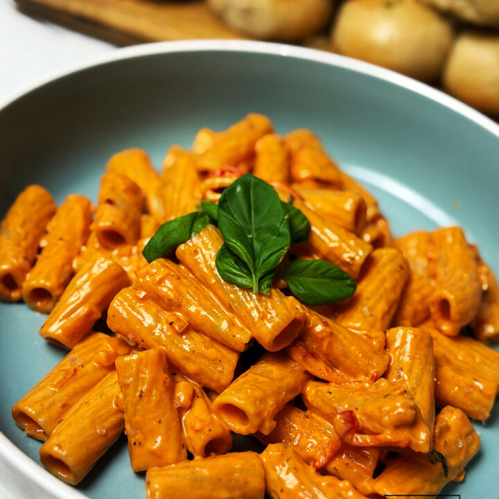 Spicy vodka pasta served in a bowl and topped with basil