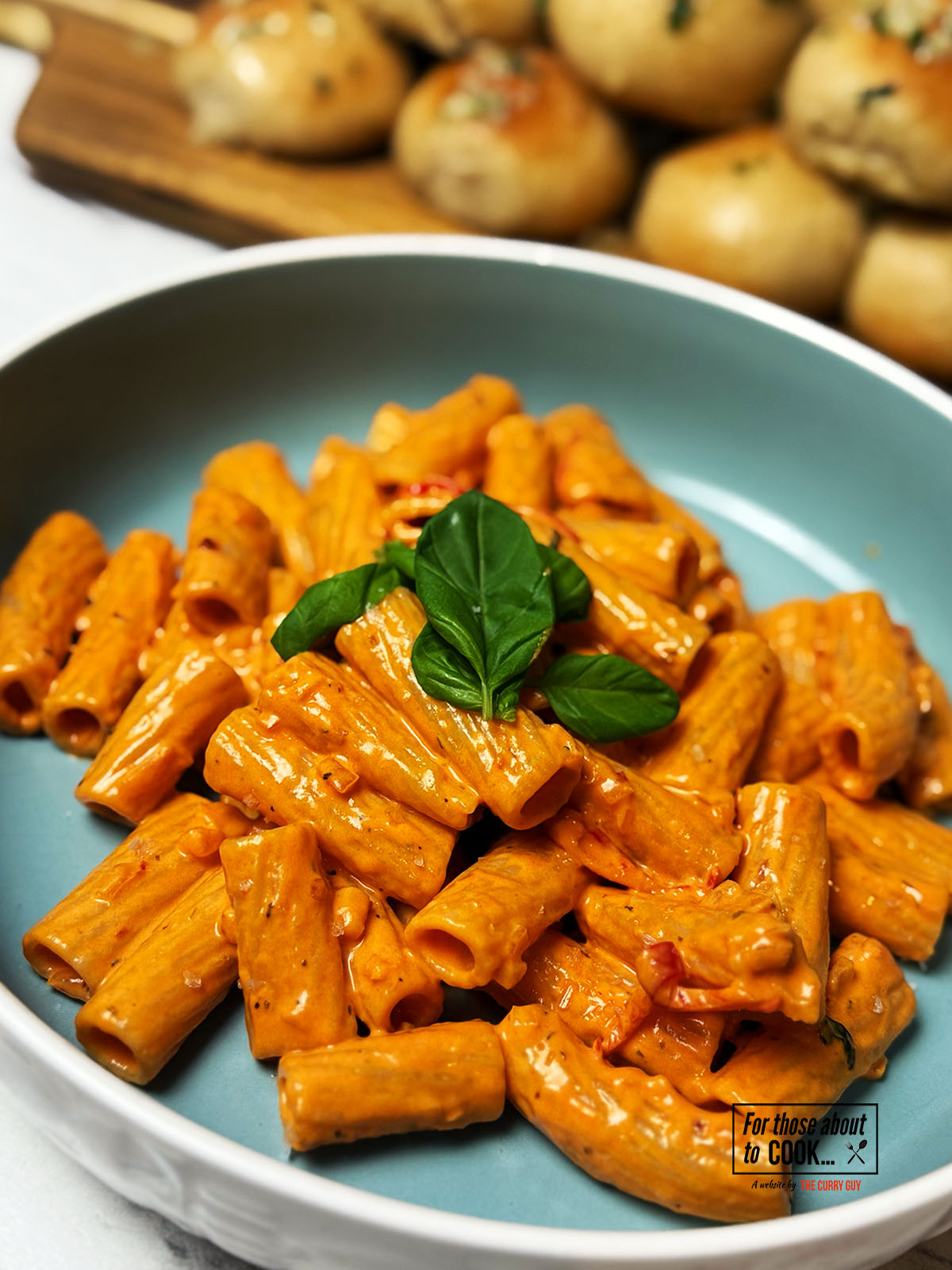 Spicy vodka pasta served in a bowl and topped with basil