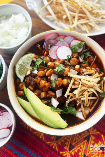 Pozole Rojo served up in a bowl with fresh toppings